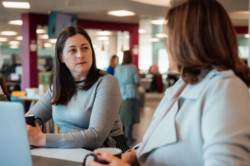 Two women sat at a table in coversation 